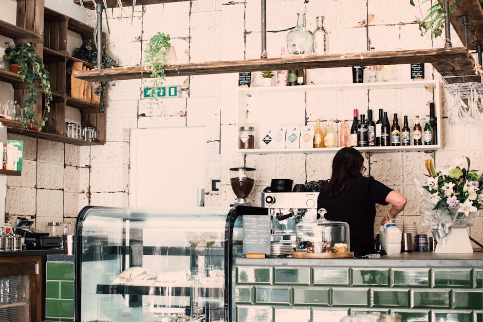 The image depicts the interior of Broomfield Park cafe during a deep cleaning in Palmers Green, as captured on the Palmers Green Carpet Cleaners website. The foreground features a wooden counter with